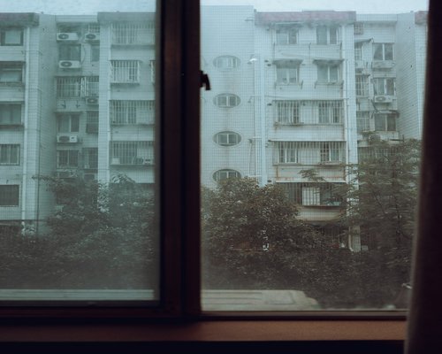View of a rainy afternoon outside a window in a city