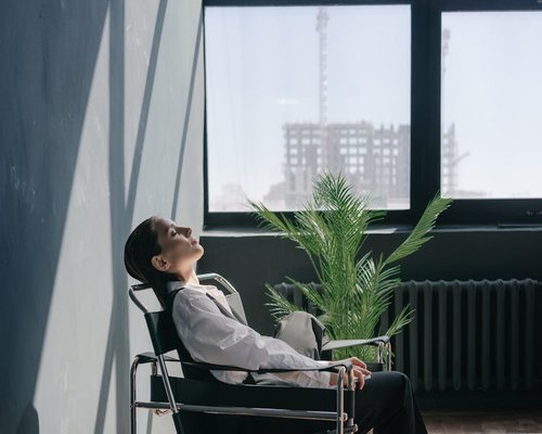 A person taking a break near a window